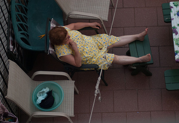 A woman takes a break from hanging laundry - Williamsburg backyard, July 2006